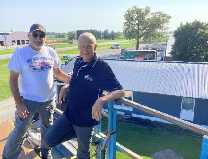 Denny Zimmerman and another contractor standing in front of a recently completed roofing job