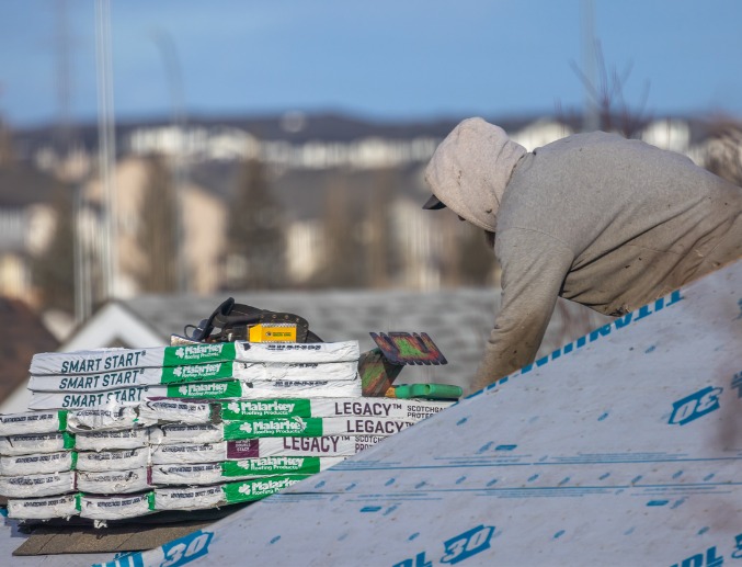 A roofer placing Malarkey Shingles onto a home's roof in Central Illinois