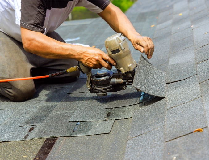 A roofer placing and repairing shingles after severe storm damage in Central Illinois