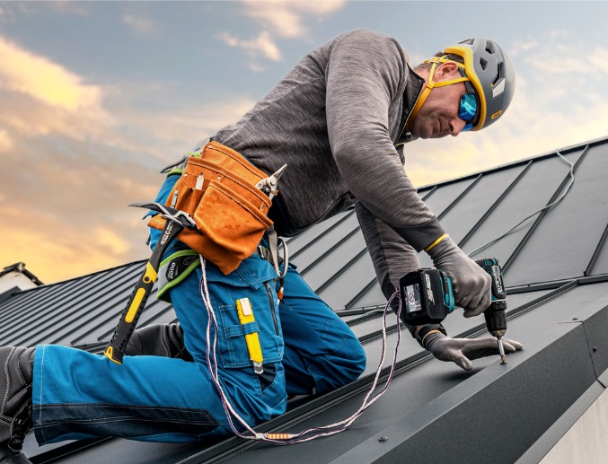 A worker helping install new commercial roofing in Illinois