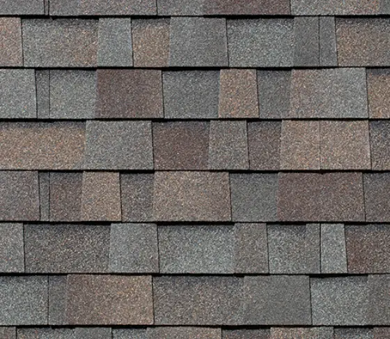 Close-up of architectural asphalt shingles showing multi-tone color blend and layered design for residential roofing